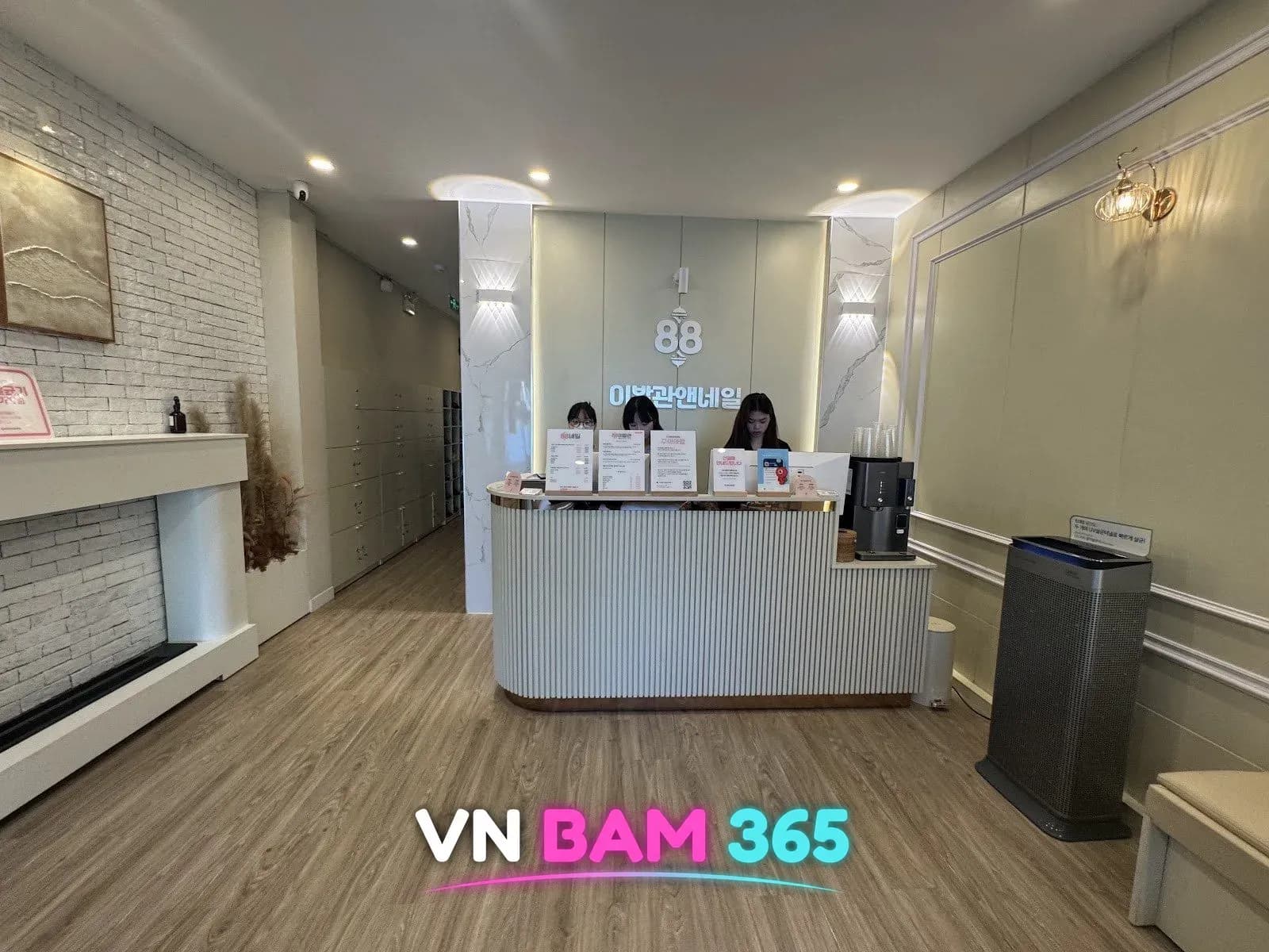 다낭 88이발관 안내 데스크, 88 이발관앤네일 로고 벽과 나무 바닥 로비