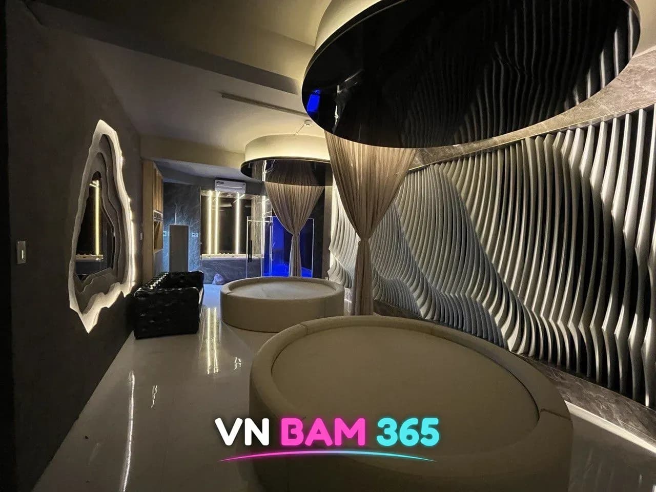 호치민 체온스파 VIP 룸의 원형 마사지 베드 두 개와 캐노피 커튼, 물결 모양 벽 패널
