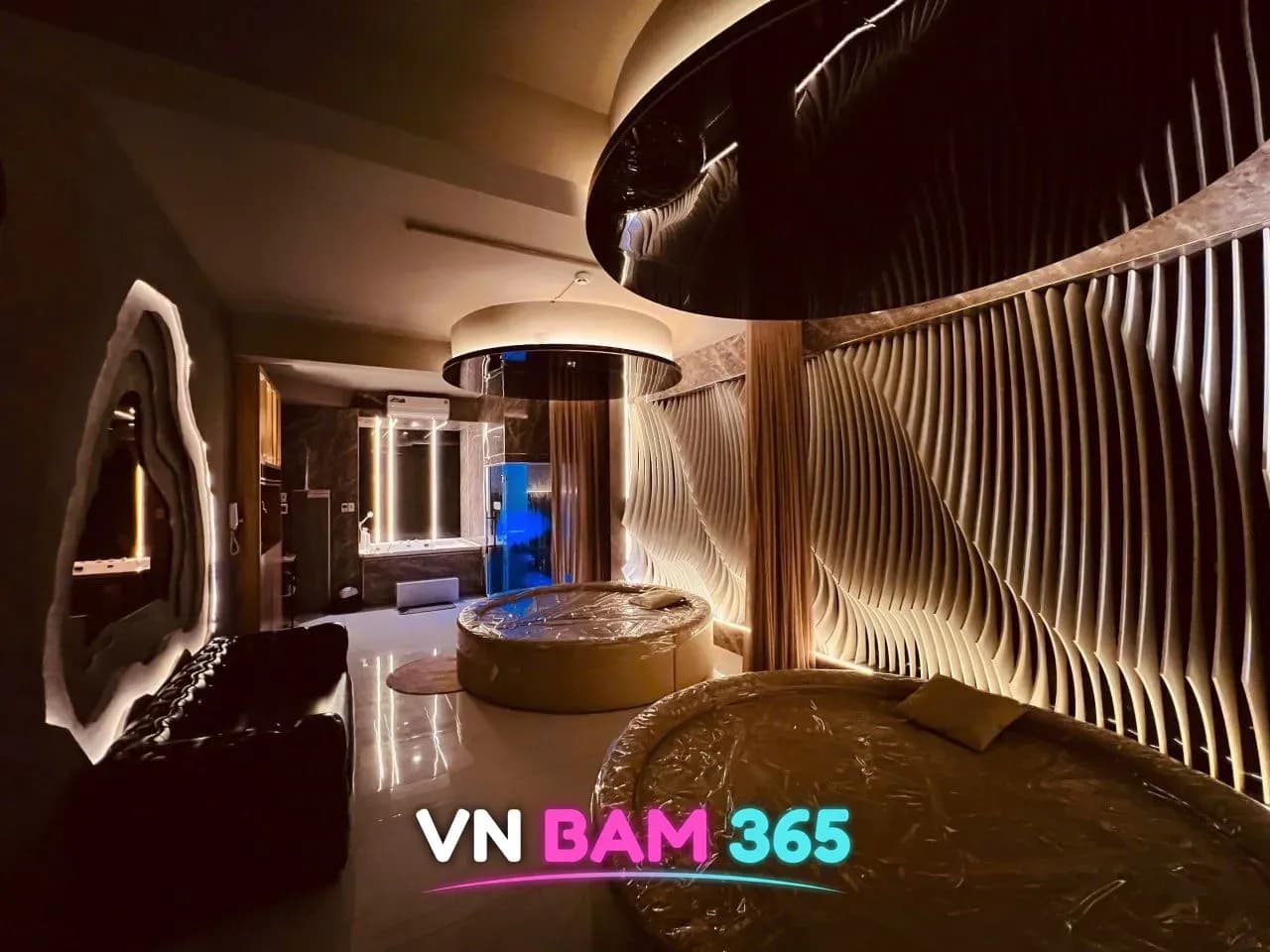 호치민 체온스파 VIP 룸의 원형 베드와 안쪽 욕조·샤워부스, 간접 조명 물결 벽