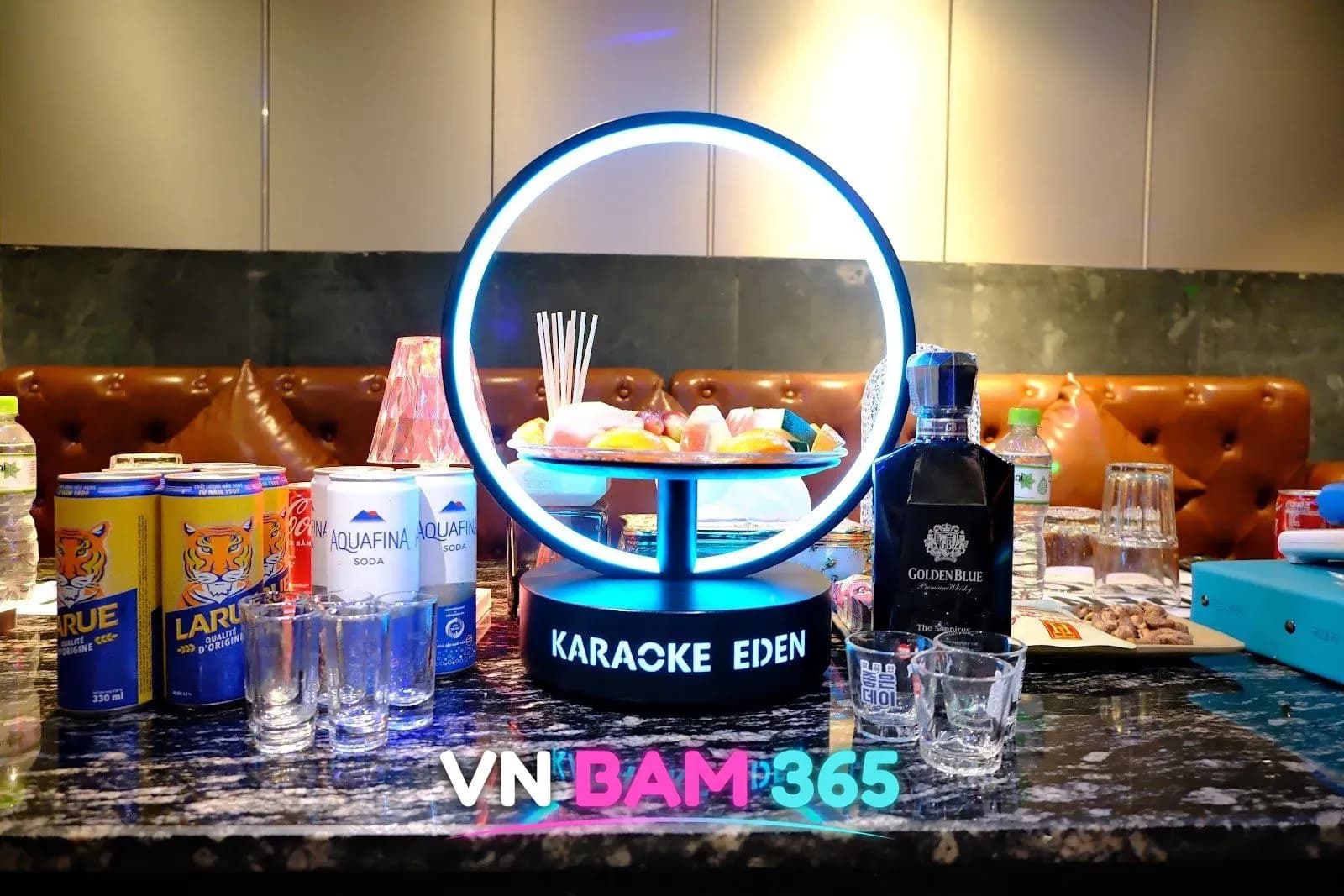 다낭 에덴 가라오케 테이블, KARAOKE EDEN 원형 조명 장식에 담긴 과일과 캔맥주·위스키·소다