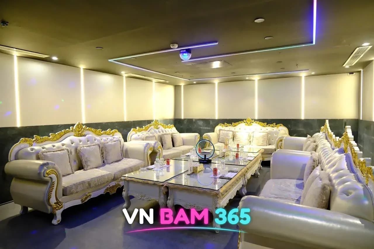 다낭 에덴 가라오케 VIP 룸, 흰색·금장 유럽풍 소파가 둘러싼 넓은 공간과 유리 테이블