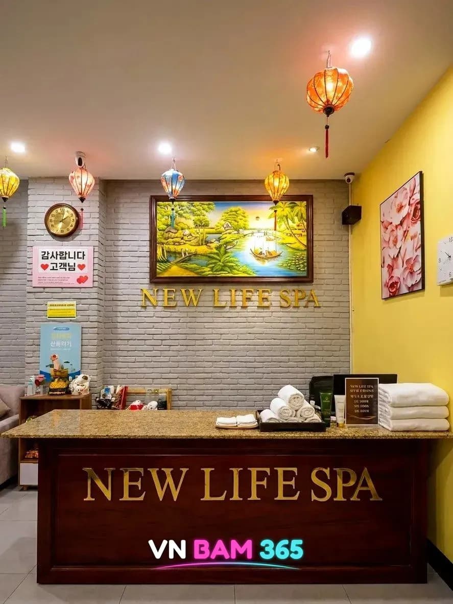 다낭 뉴라이프 스파 리셉션, 풍경화와 NEW LIFE SPA 금색 로고, 수건을 올린 카운터