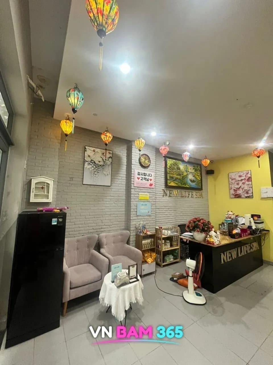 다낭 뉴라이프 스파 로비 실사, 흰 벽돌 벽과 등롱, 리셉션 카운터