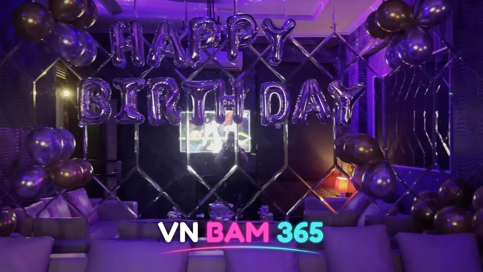 다낭 로마 라운지 노래방 룸, 보라 조명 아래 HAPPY BIRTHDAY 풍선 장식과 흰 소파