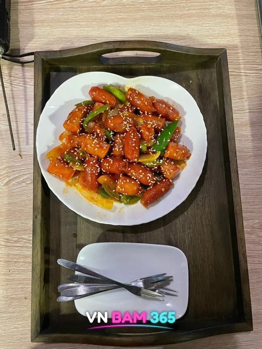 다낭 로마 라운지 안주, 나무 쟁반 위 접시에 담긴 깨를 뿌린 떡볶이