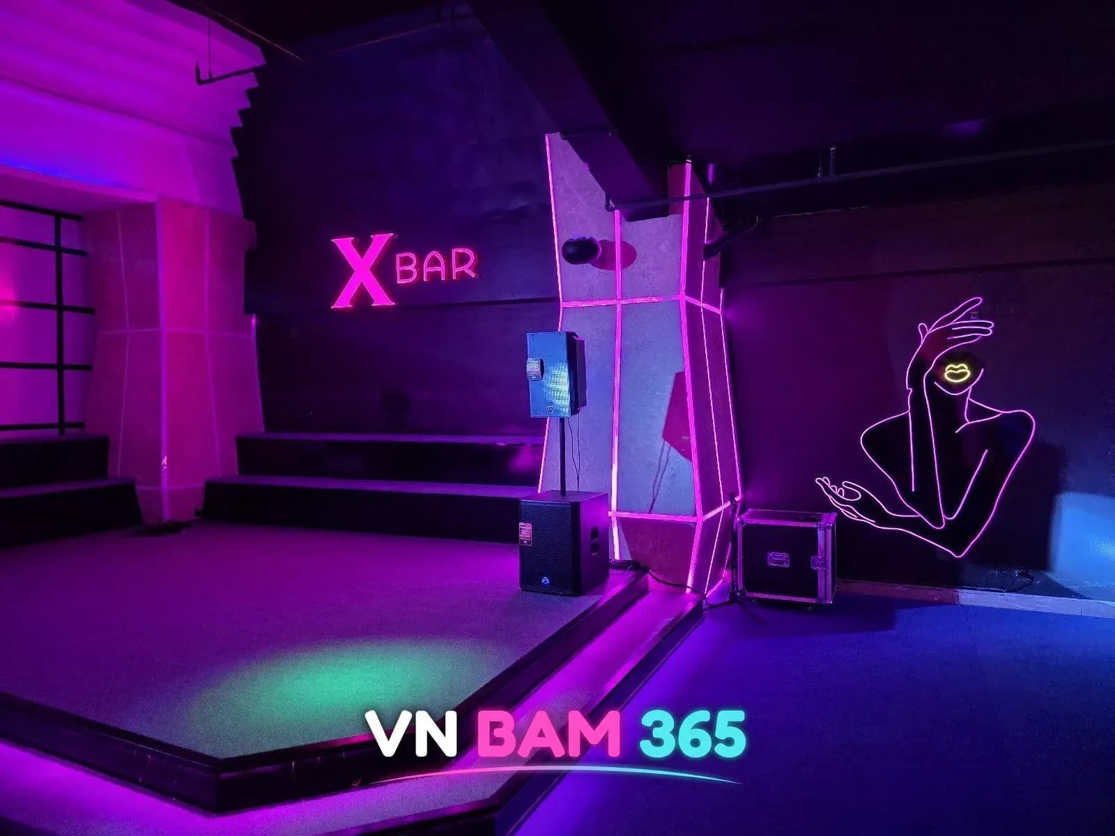 다낭 엑스바 무대, 보라 조명의 X BAR 네온 로고와 스피커, 선으로 그린 인물 네온 장식