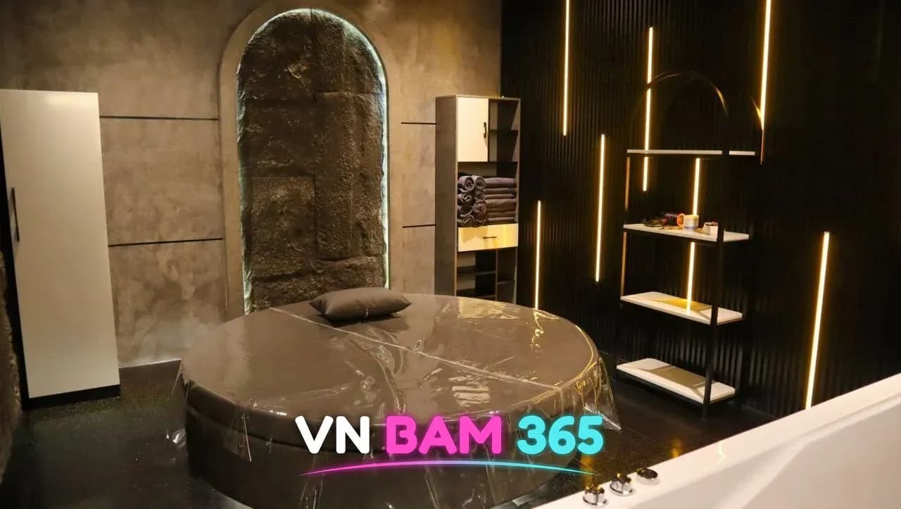 호치민 도도 스파 프라이빗 룸 전경, 돌벽 아치 앞 원형 베드와 욕조, 조명 선반