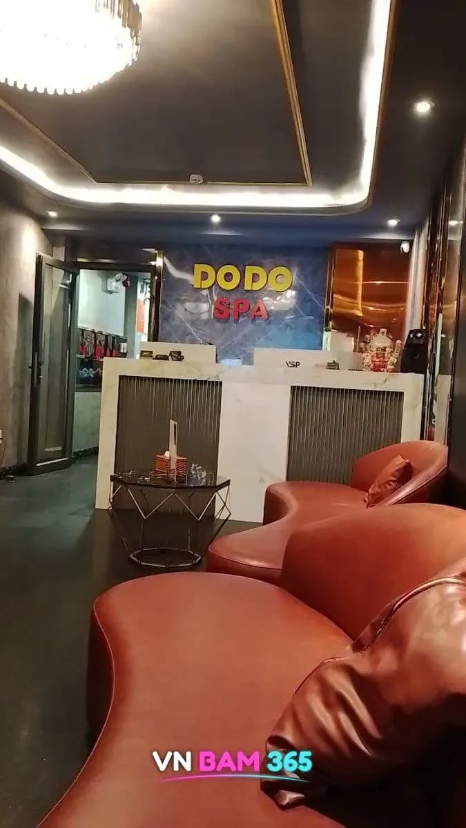 호치민 도도 스파 리셉션, DODO SPA 로고 벽 앞 대리석 데스크와 주황 소파