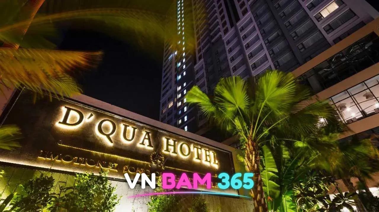 나트랑 디쿠아 호텔 야간 입구 간판, 금색 조명 D'QUA HOTEL 로고와 야자수, 고층 타워