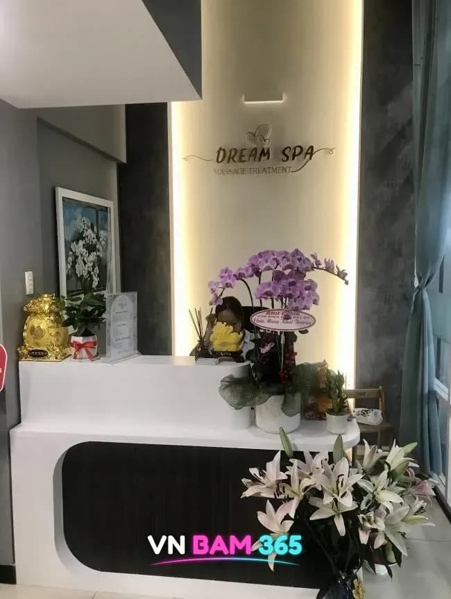호치민 7군 드림 마사지 리셉션 데스크, DREAM SPA 로고 조명과 난초 화분