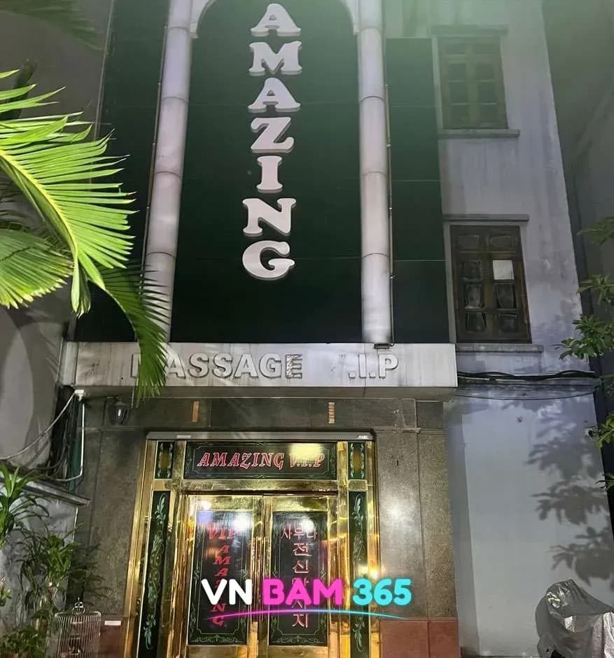하노이 어메이징 VIP 마사지 건물 전면, 세로로 쓴 AMAZING 간판과 1층 금색 출입문