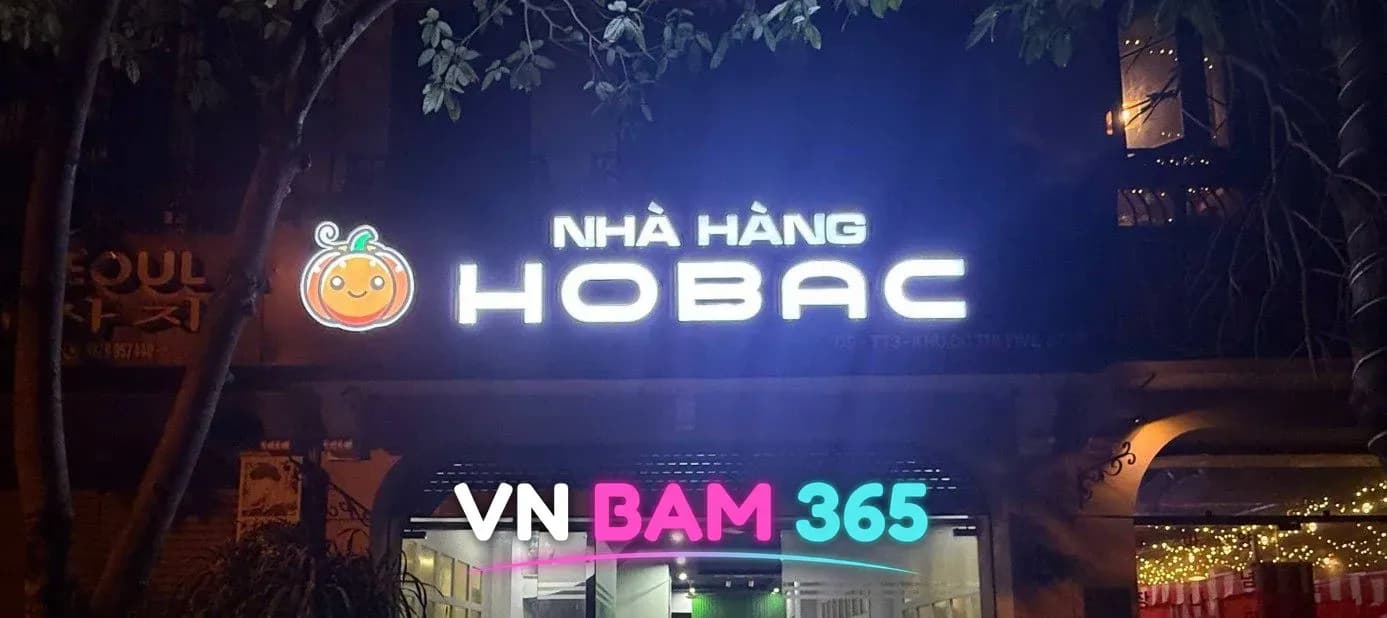 하노이 호박 셔츠룸 야간 외관, 호박 캐릭터 로고와 NHÀ HÀNG HOBAC 조명 간판