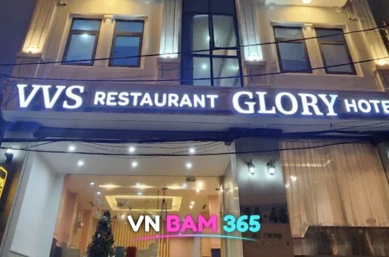 하노이 VVS 가라오케 건물 정면, 흰 조명 간판과 크리스마스트리가 보이는 로비