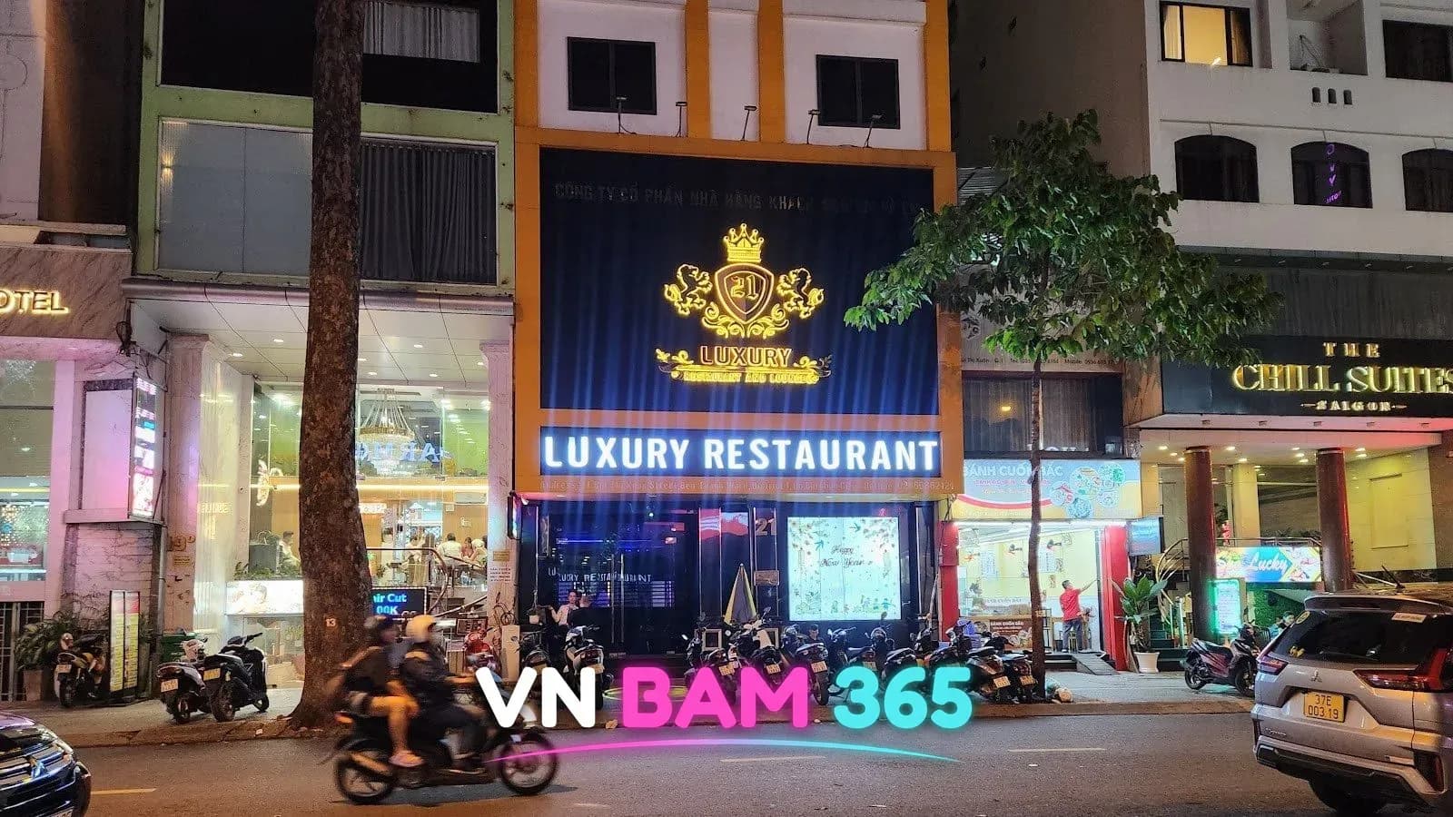 호치민 1군 부이티쑤언 거리 21 LUXURY RESTAURANT 야간 외관, 왕관 로고 간판과 21번지 출입문
