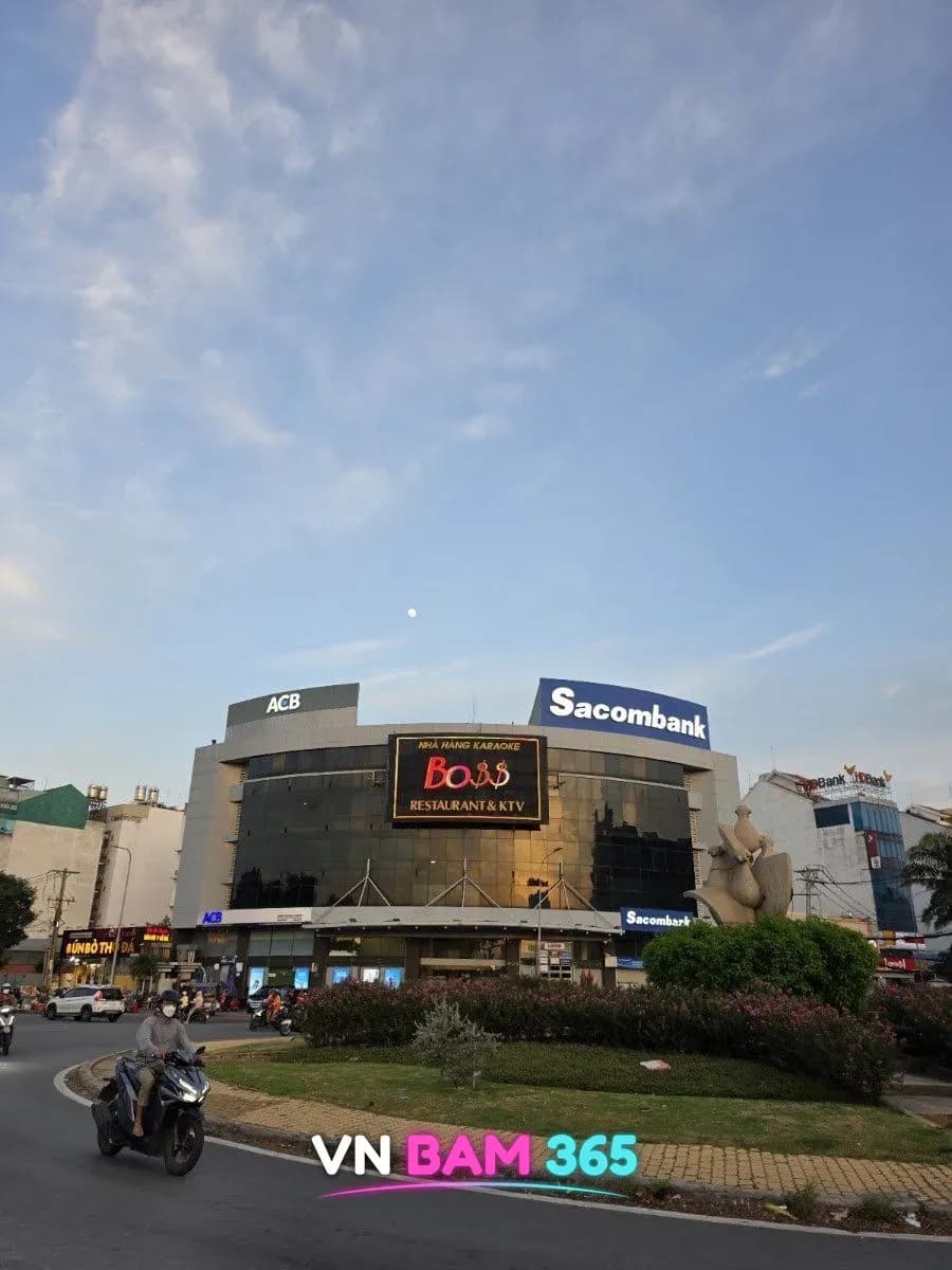 호치민 빈찐 중선 지역 SISC 빌딩 외관, 건물 정면의 BOSS RESTAURANT & KTV 간판과 로터리