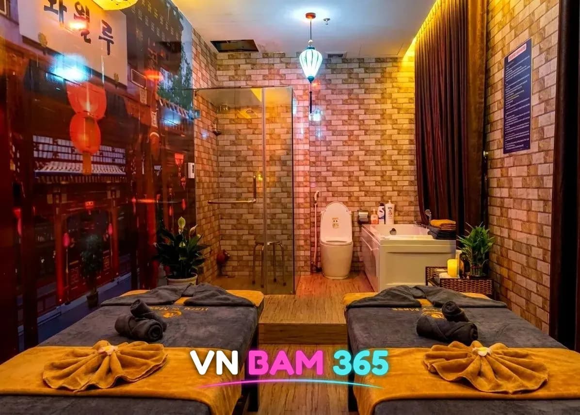 다낭 화월루 벽돌 타일 룸의 마사지 베드 두 개와 샤워부스, 욕조, 붉은 등이 걸린 옛 거리 벽화