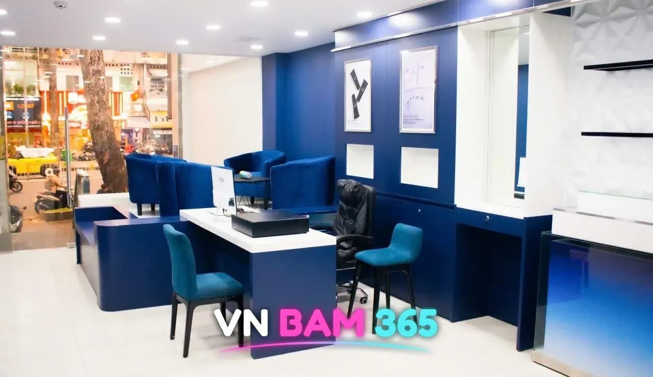 호치민 킹스톤 마사지 1층 리셉션, 남색 벽과 흰 데스크, 파란 벨벳 라운지 의자와 거리로 난 유리창