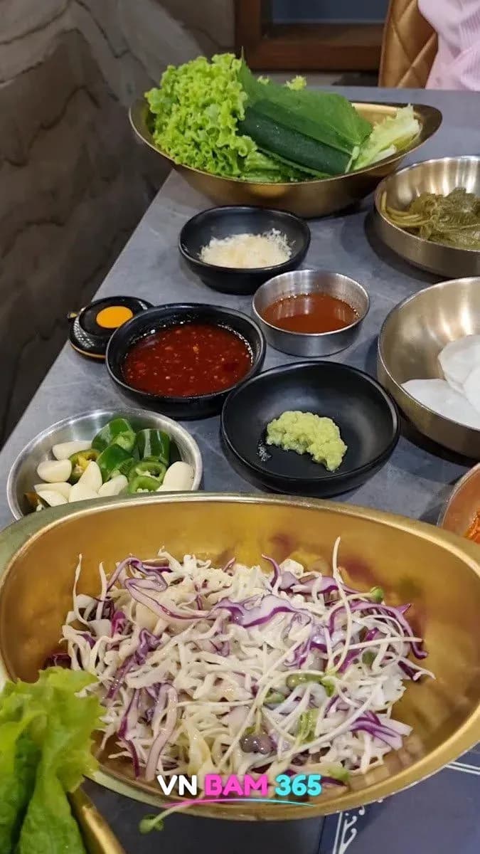 나트랑 금돼지 비비큐 기본 상차림, 금색 그릇의 상추·깻잎과 양배추 샐러드, 마늘·고추·양념장·쌈장