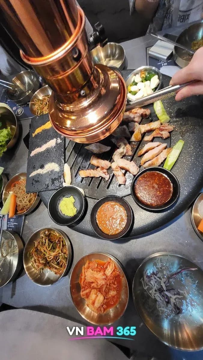 나트랑 금돼지 비비큐 구리 연통 불판에서 굽는 돼지고기와 소스·김치 반찬