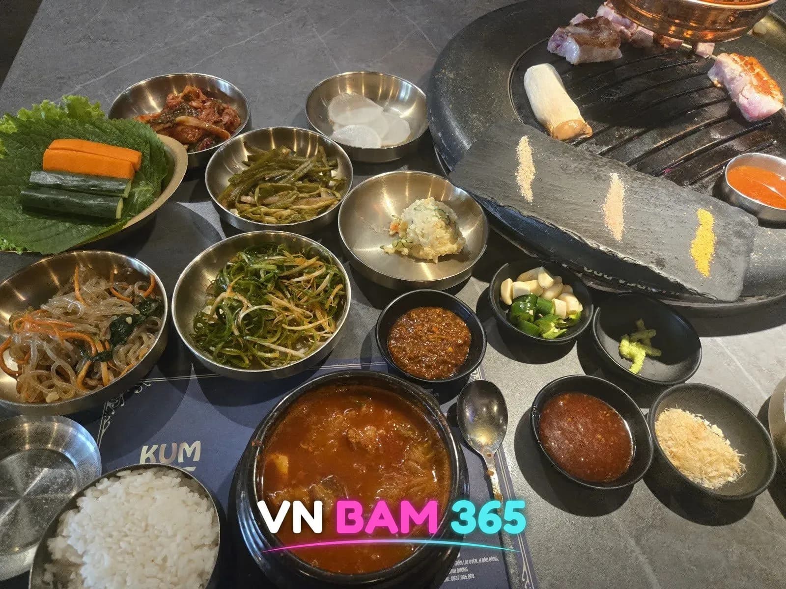 나트랑 금돼지 비비큐 상차림, 김치찌개·밥·잡채·파무침 등 반찬과 불판 위 삼겹살