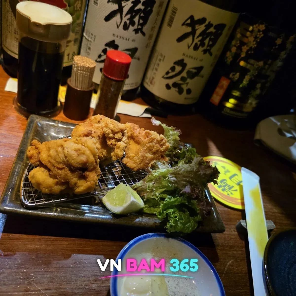 호치민 1군 망게츠 소주 바 닭 가라아게와 라임·양상추, 뒤로 닷사이 사케 병