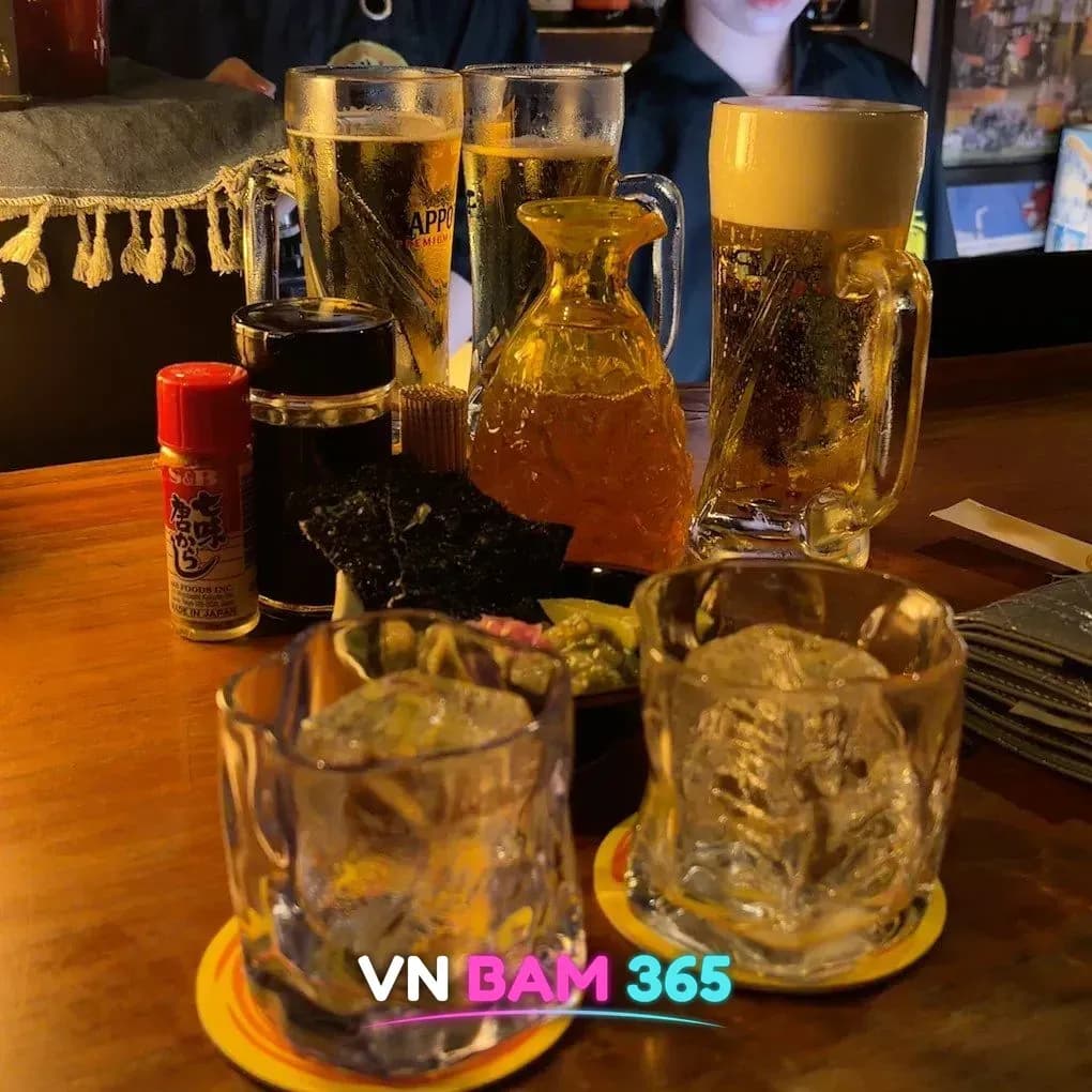 호치민 1군 레탄톤 망게츠 소주 바 카운터 위 생맥주 잔과 얼음 소주잔, 시치미·김 안주