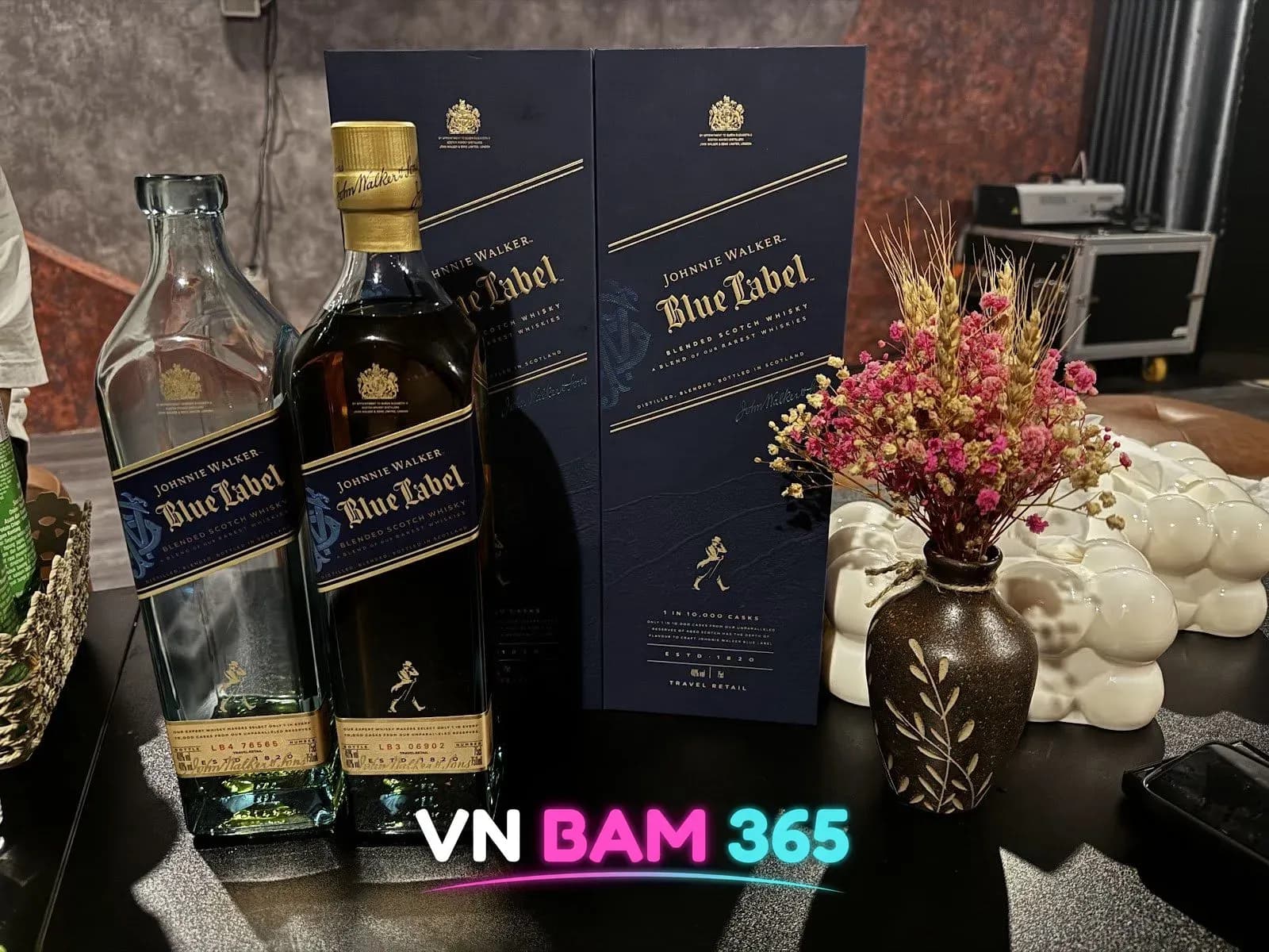 나트랑 버니바 테이블의 조니워커 블루라벨 병과 상자, 드라이플라워 꽃병