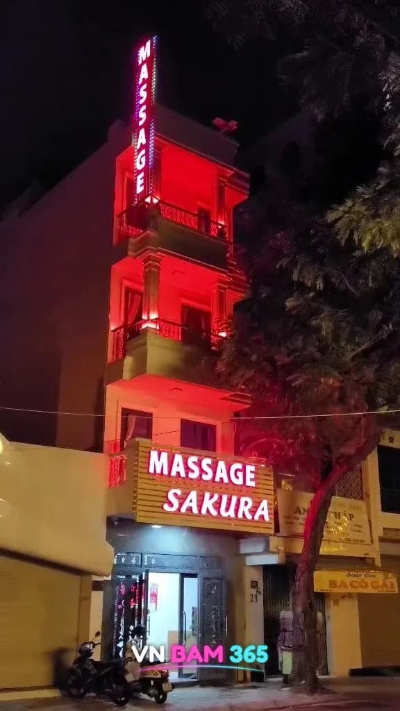 나트랑 사쿠라 마사지 야간 외관, 붉은 조명이 켜진 4층 건물과 MASSAGE SAKURA 간판