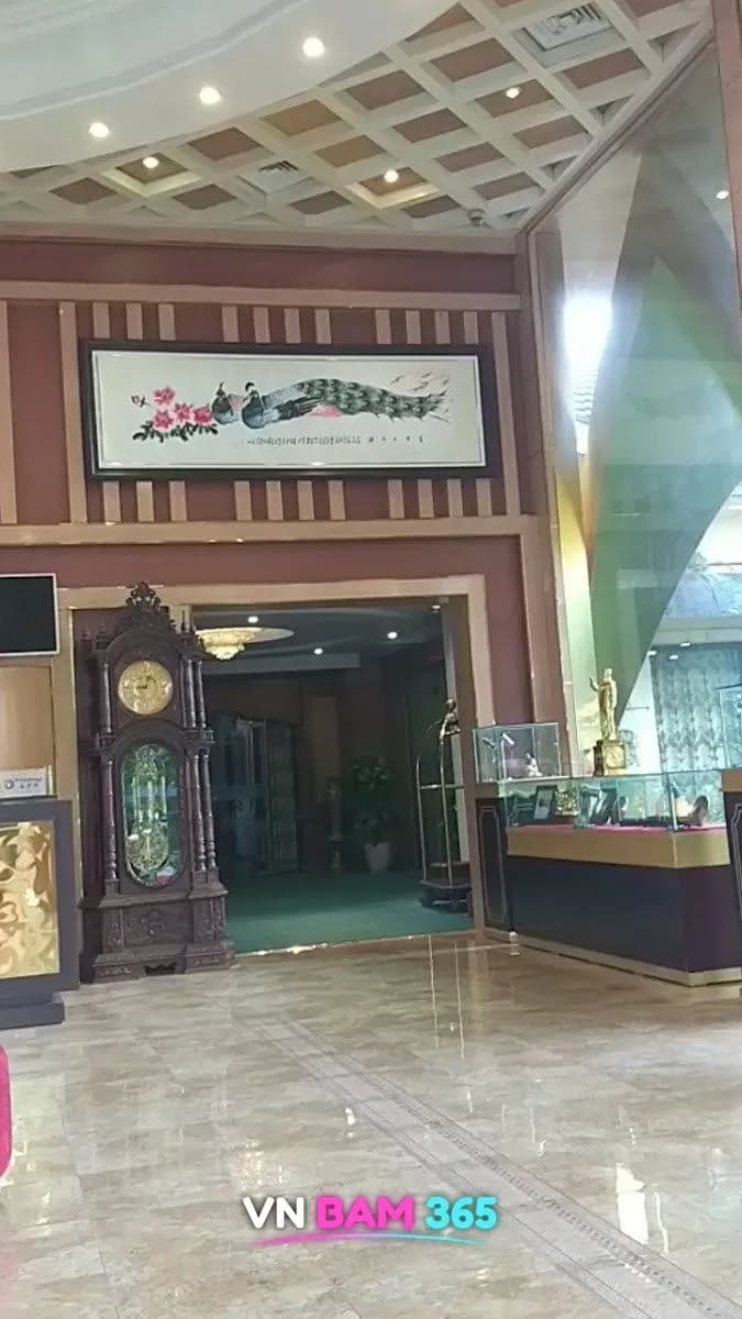 박닌 피닉스 리조트 로비의 대리석 바닥과 앤티크 괘종시계, 공작 그림 액자, 진열장