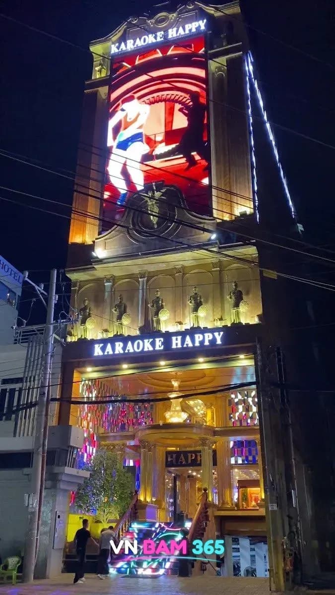 푸꾸옥 해피 가라오케 대형 전광판과 KARAOKE HAPPY 간판이 있는 야간 건물 전경