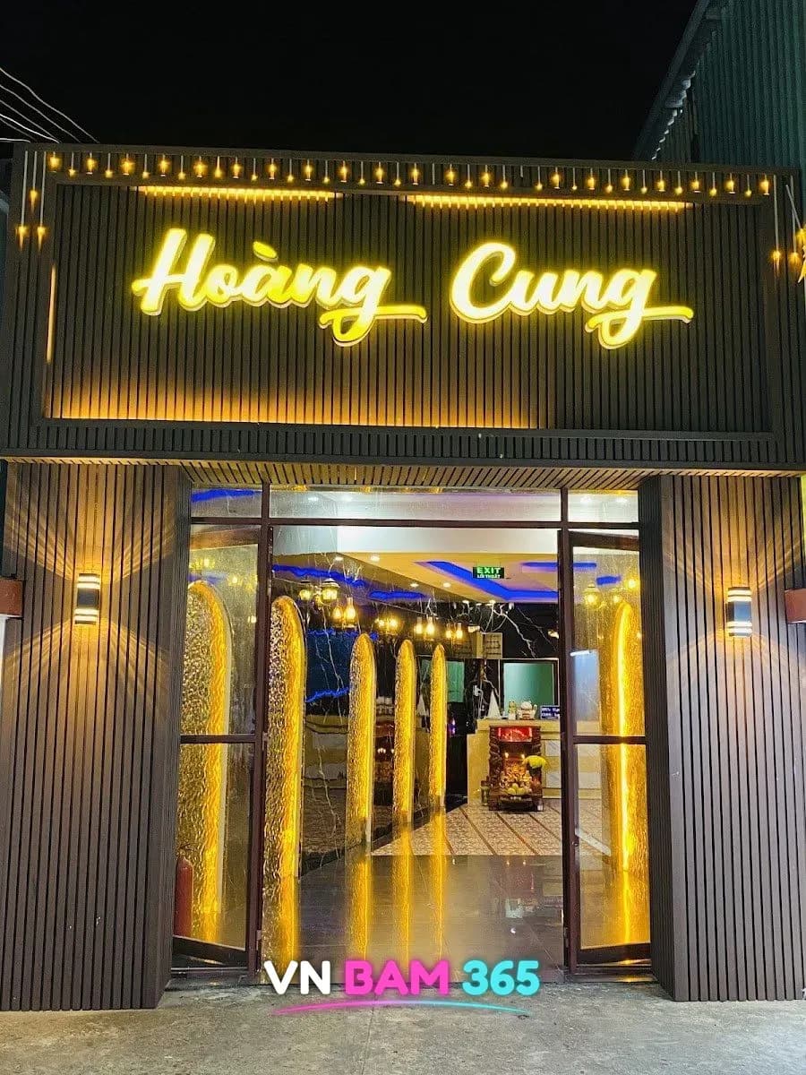 푸꾸옥 황궁 마사지 입구 위 노란 Hoàng Cung 조명 간판과 아치형 조명 장식이 보이는 로비