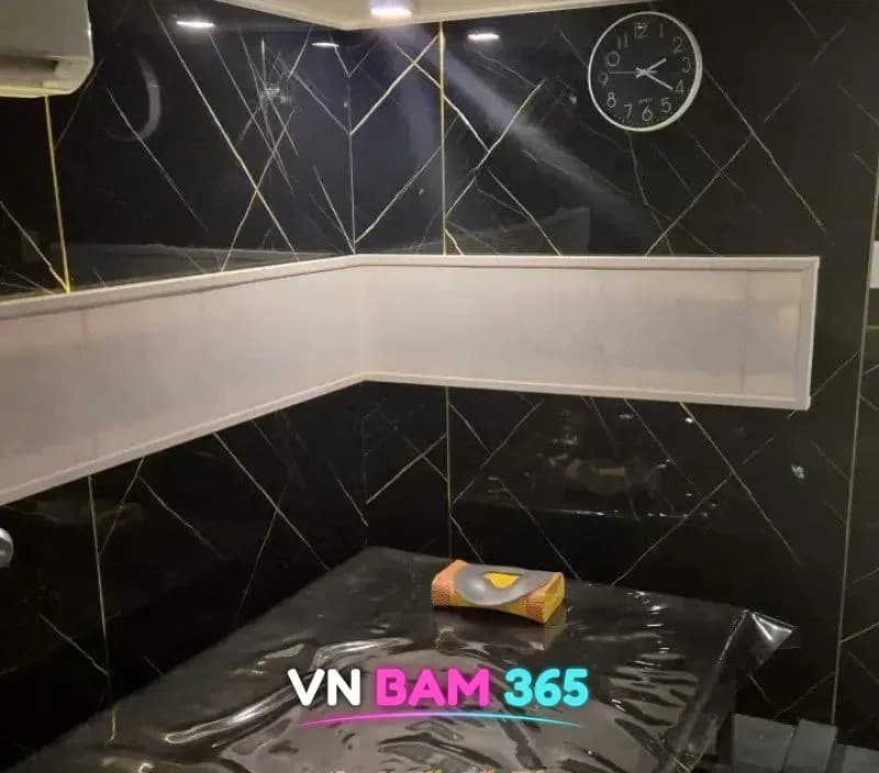 호치민 딸기 때밀이 스파 세신 룸, 검은 대리석 벽과 세신 베드, 벽시계