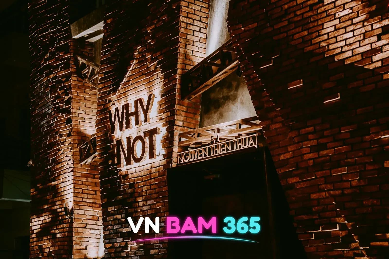 나트랑 와이낫 바 입구, 벽돌 벽의 WHY NOT 조명 글자와 응우옌티엔투엇 거리명 표지