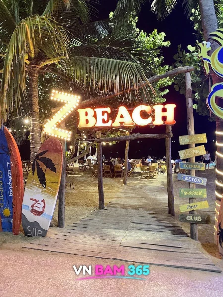 나트랑 Z비치 입구, Z BEACH 전구 간판과 서핑보드·방향 표지판, 나무 데크 길