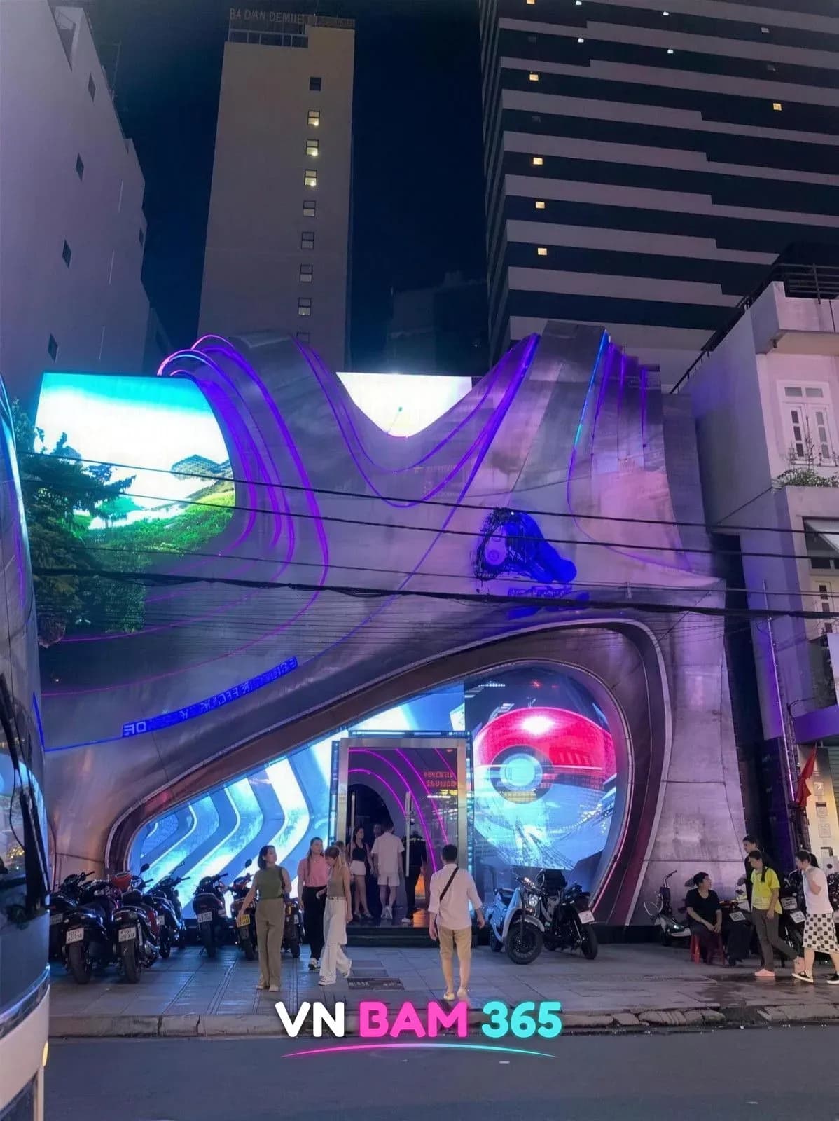 나트랑 알파 클럽 야간 외관, 보라색 조명 곡면 금속 파사드와 대형 LED 스크린 입구
