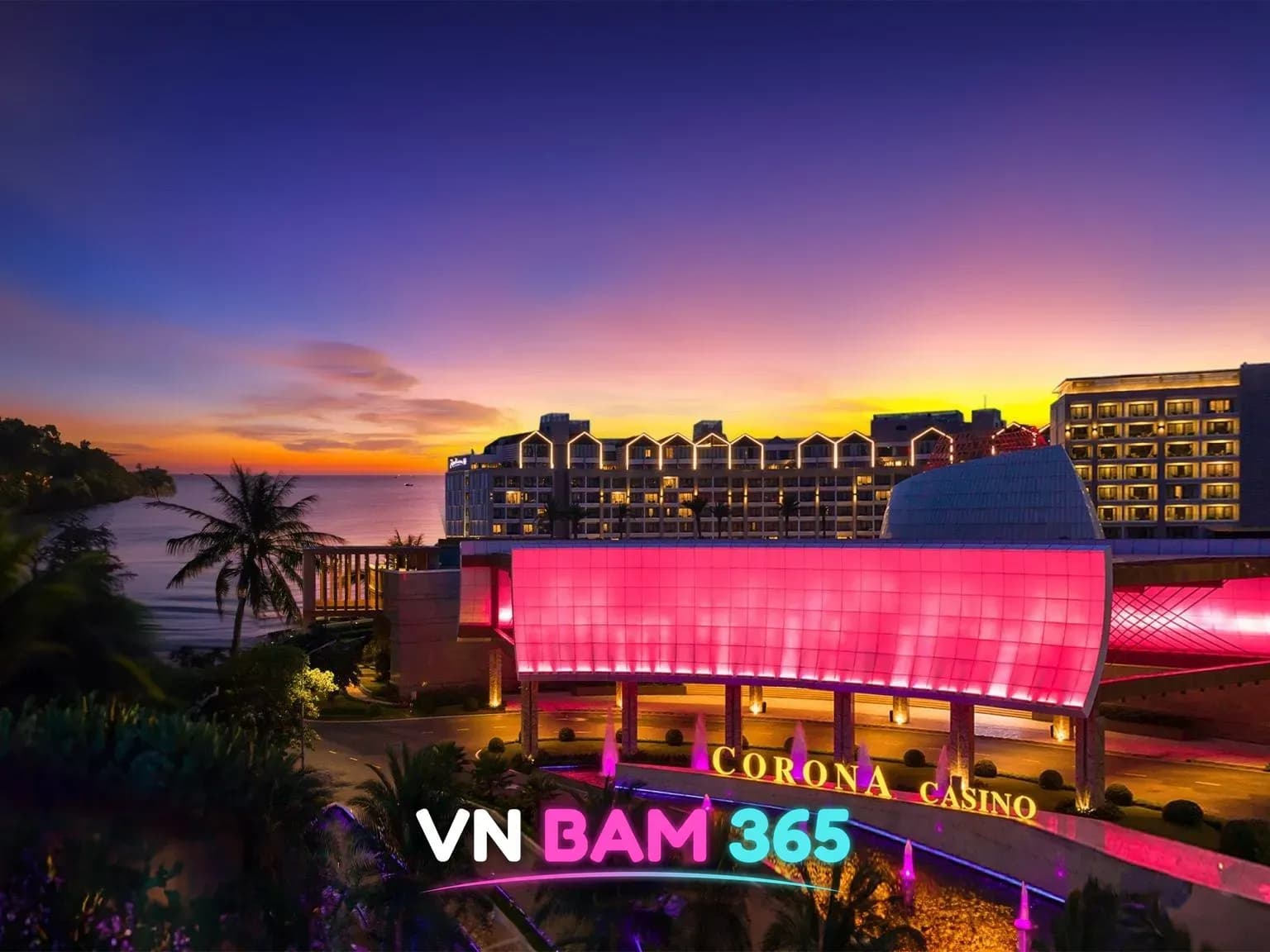 푸꾸옥 코로나 카지노 핑크빛 조명 입구와 CORONA CASINO 간판, 뒤로 호텔과 바다 노을