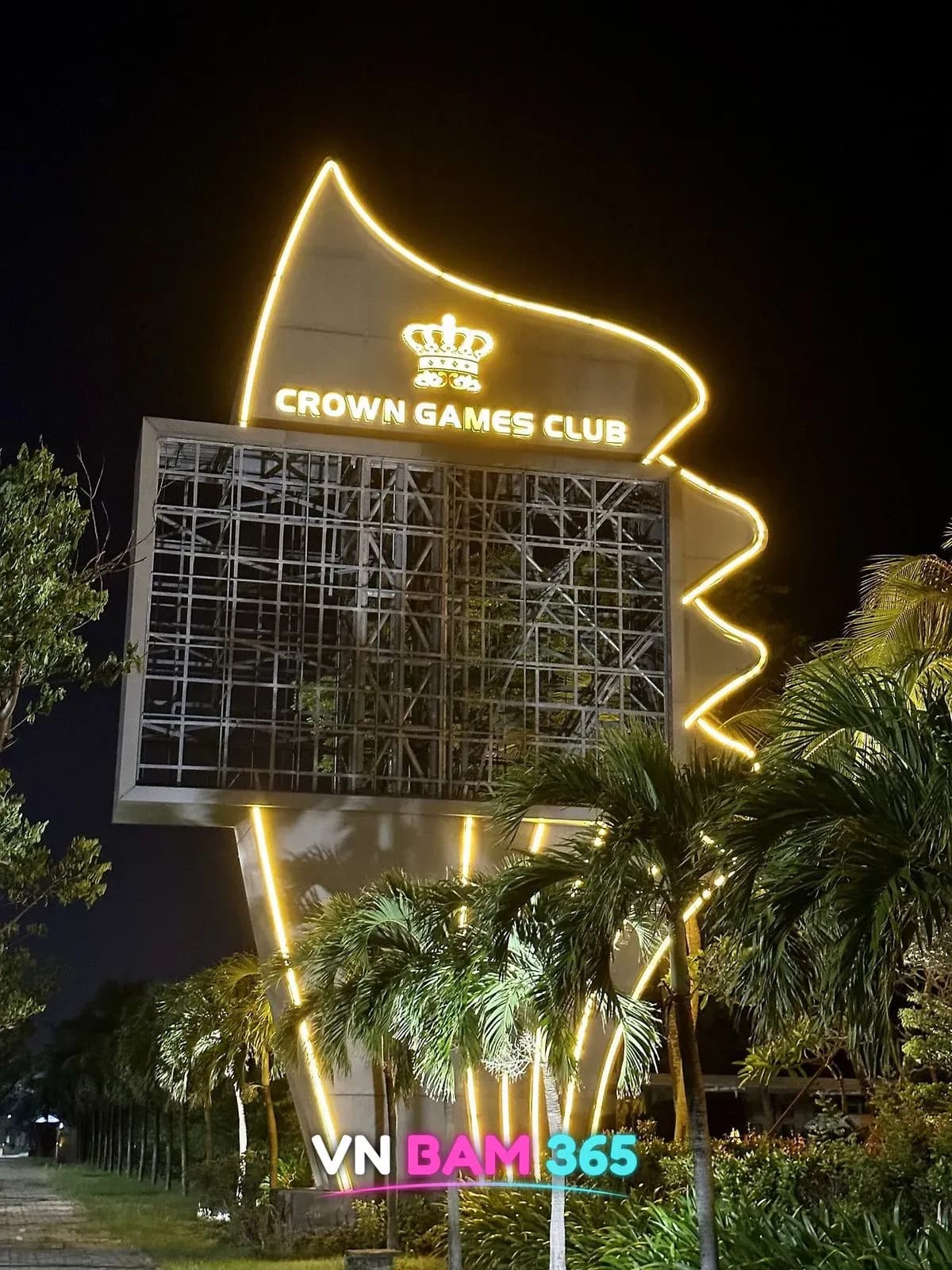 다낭 크라운 카지노 진입로의 CROWN GAMES CLUB 왕관 조명 간판탑과 야자수