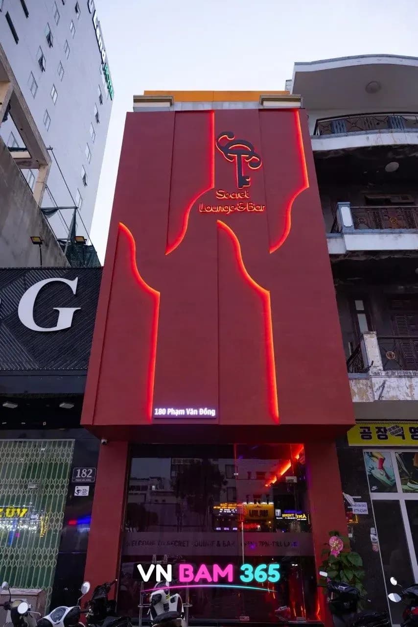 다낭 시크릿 라운지 외관, 붉은 조명 선이 들어간 건물 전면의 Secret Lounge & Bar 열쇠 로고 간판