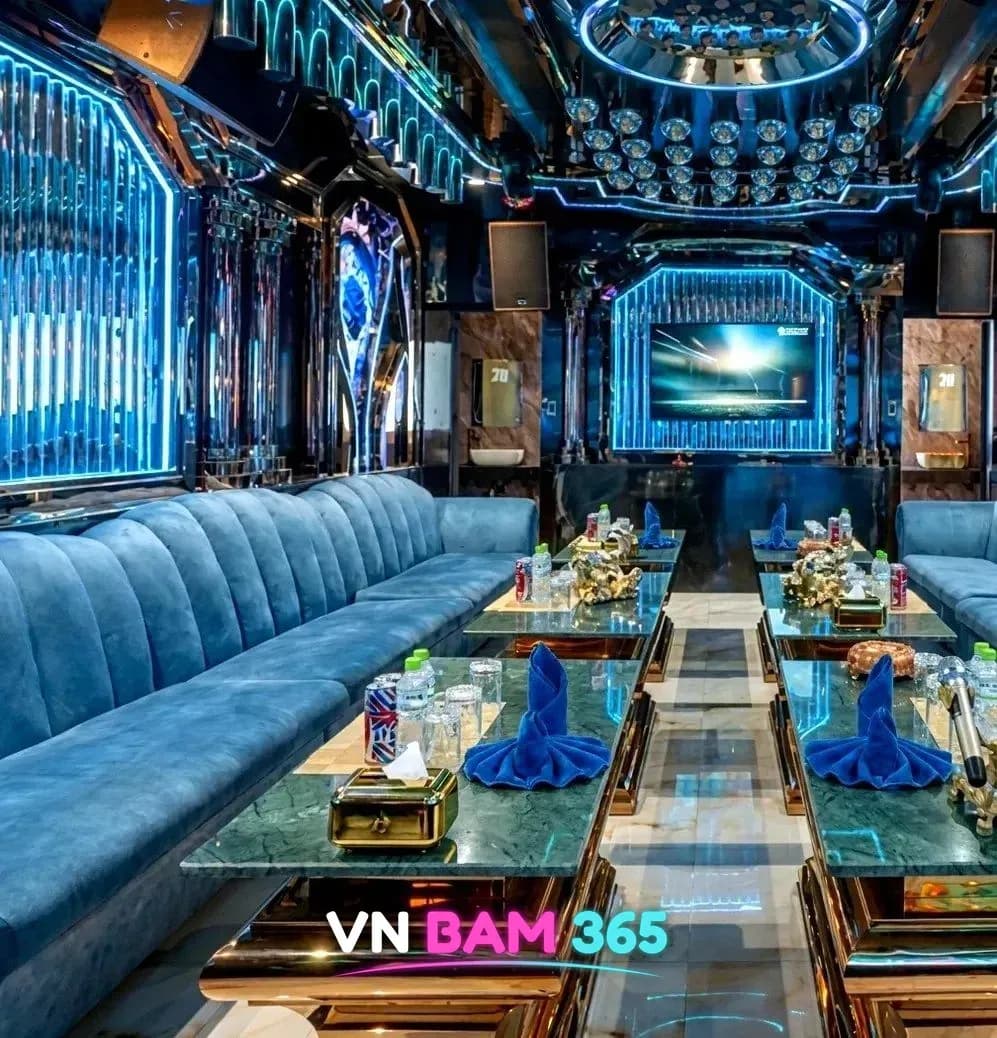 다낭 더나인 가라오케 대형 VIP 룸, 파란 네온 조명과 파란 벨벳 소파가 양쪽으로 길게 놓인 모습