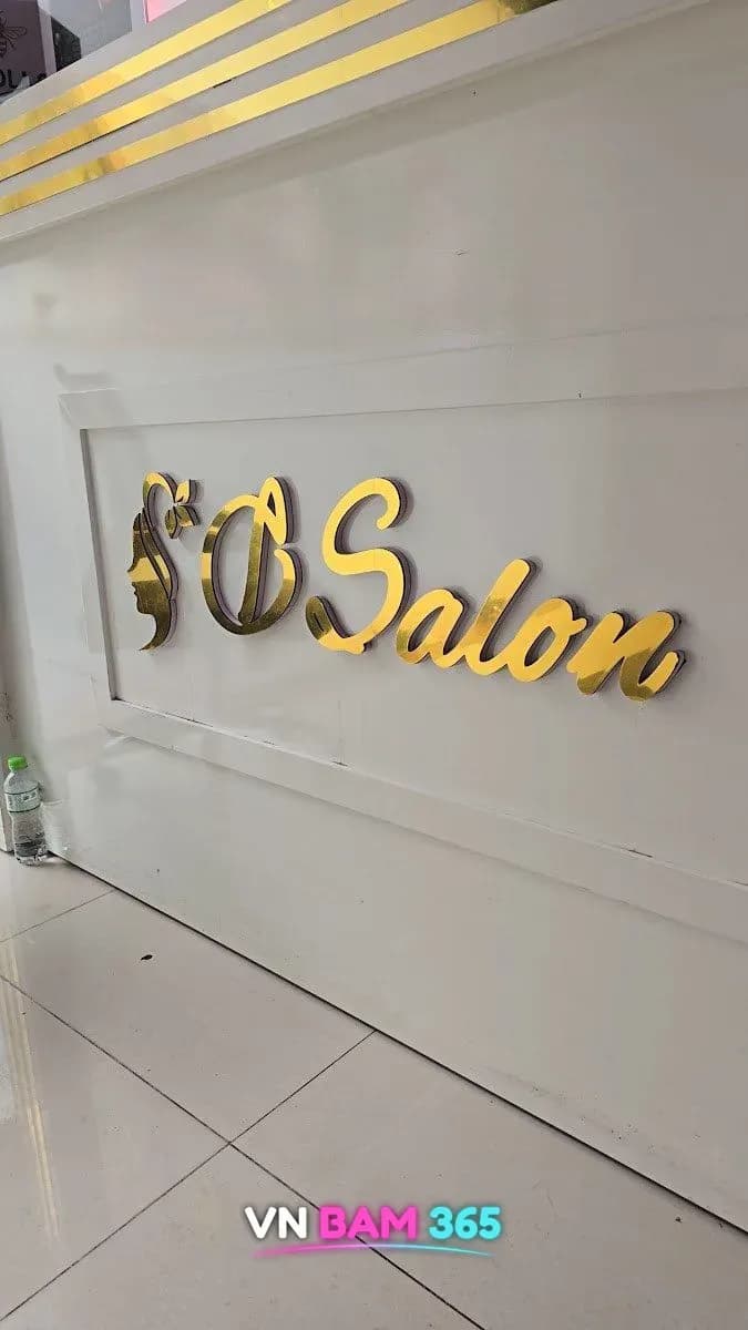 하노이 디살롱 실내 흰 벽면의 금색 D Salon 로고 사인