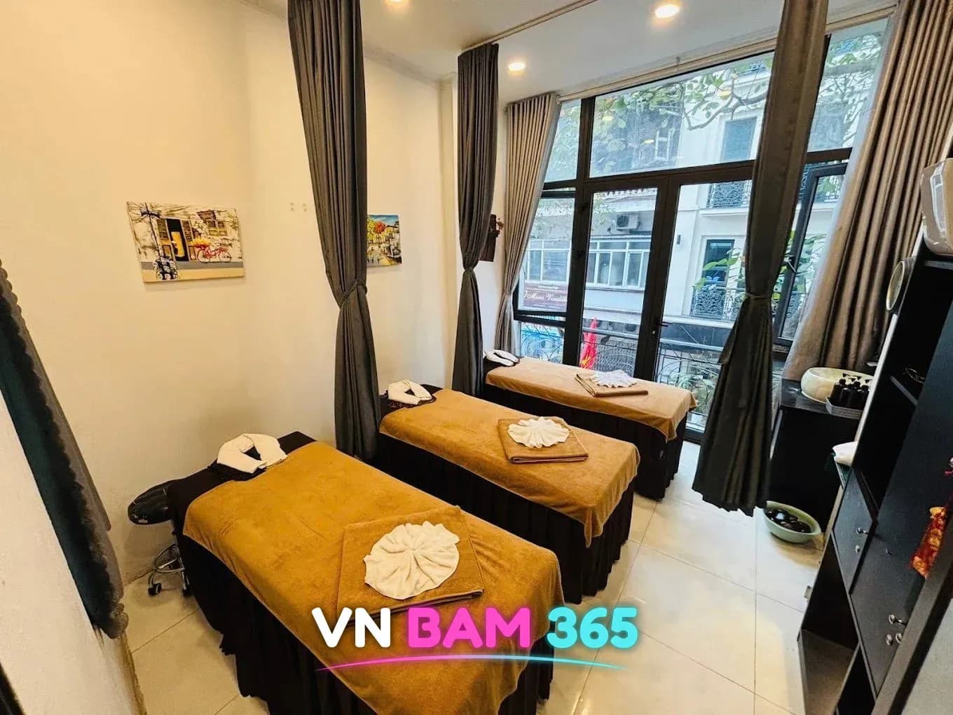 하노이 썬 VIP 마사지 밝은 마사지 룸, 갈색 수건을 덮은 베드 3개와 회색 커튼, 통유리 창