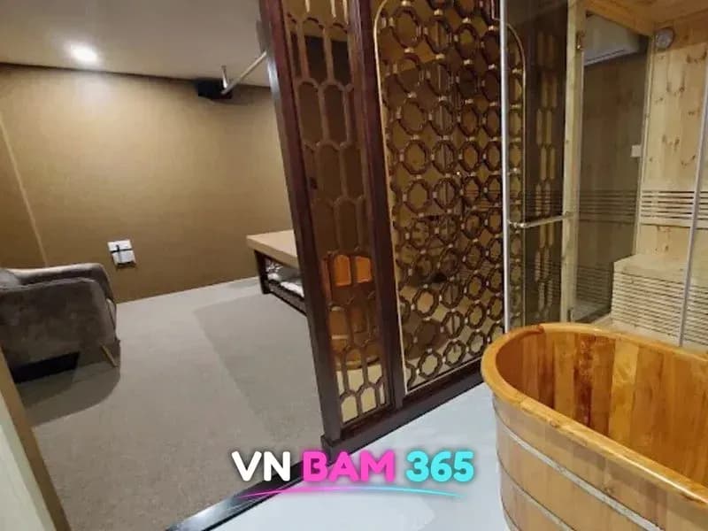호치민 루나 마사지 룸 안 원목 욕조와 유리문 사우나, 격자 칸막이 너머 마사지 베드