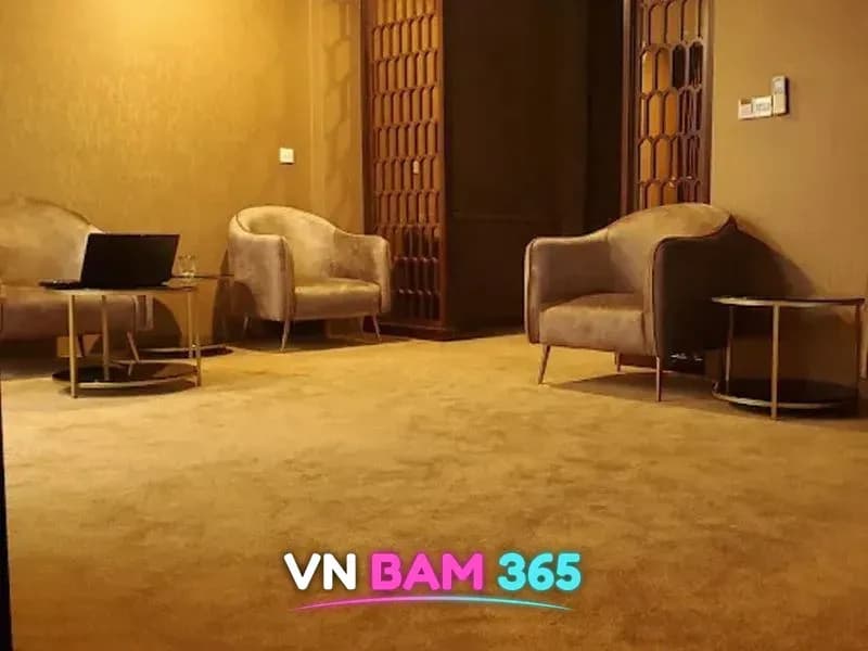 호치민 루나 마사지 라운지, 베이지 카펫 위 벨벳 안락의자와 원형 협탁, 격자 장식 문