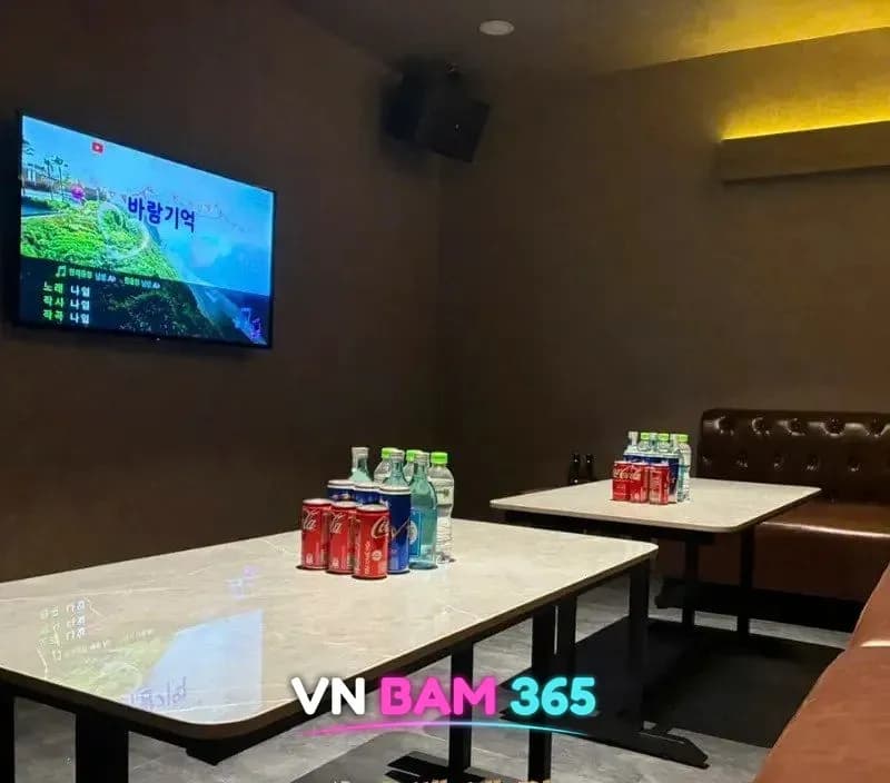 호치민 3군 홈런볼 가라오케 룸, 갈색 가죽 소파와 대리석 테이블, 벽걸이 노래방 화면