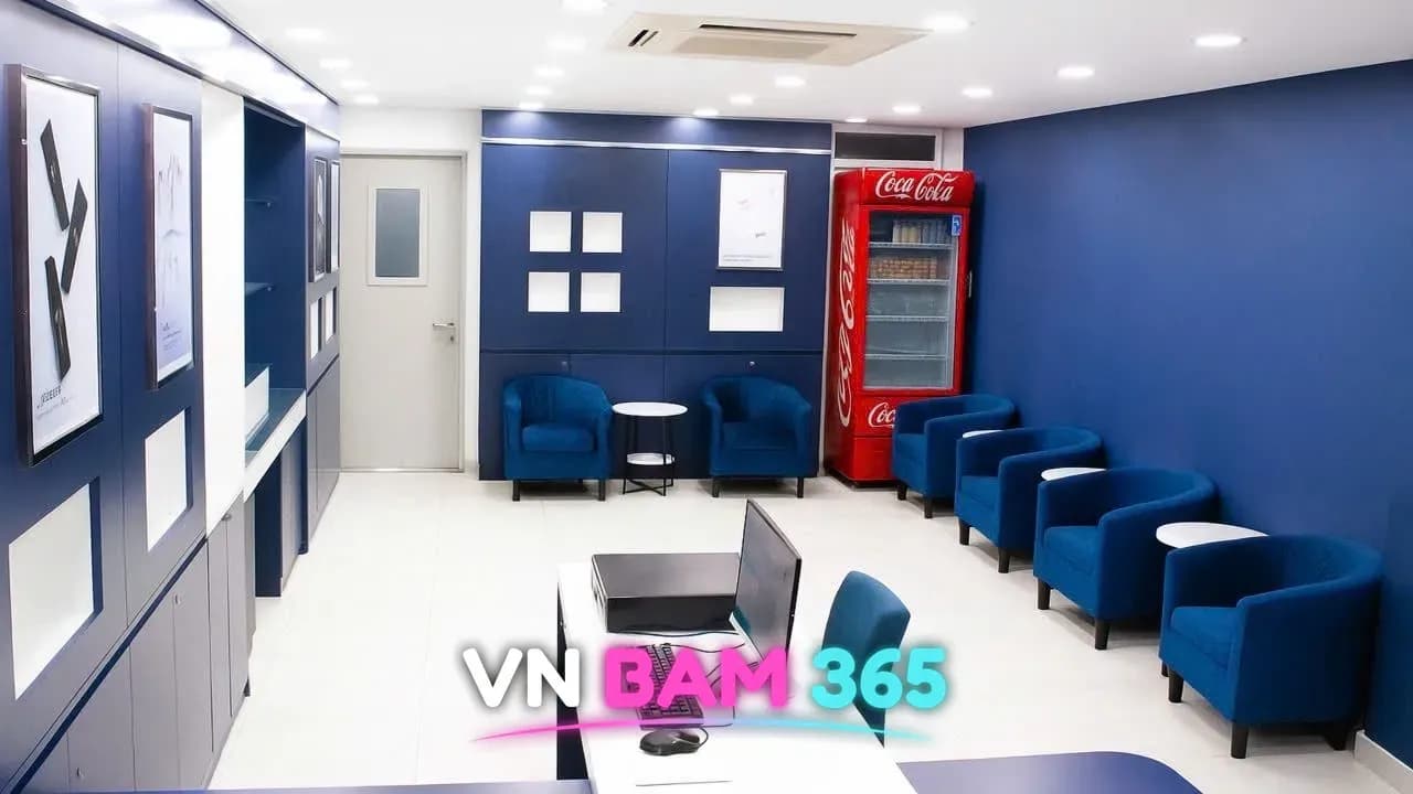 호치민 킹스톤 마사지 대기 라운지, 벽을 따라 놓인 파란 벨벳 1인 소파와 음료 냉장고, 리셉션 데스크