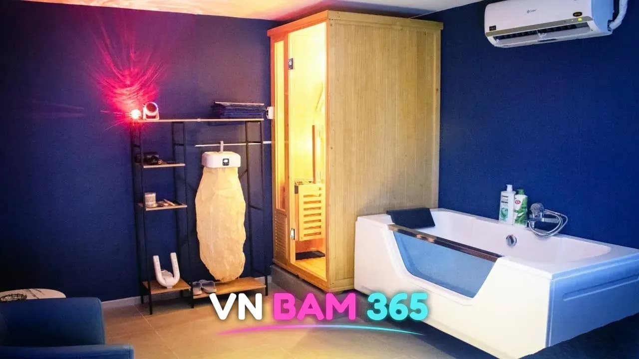 호치민 킹스톤 마사지 VIP룸 안 원목 1인 사우나와 유리창 욕조, 수건과 비품이 놓인 선반