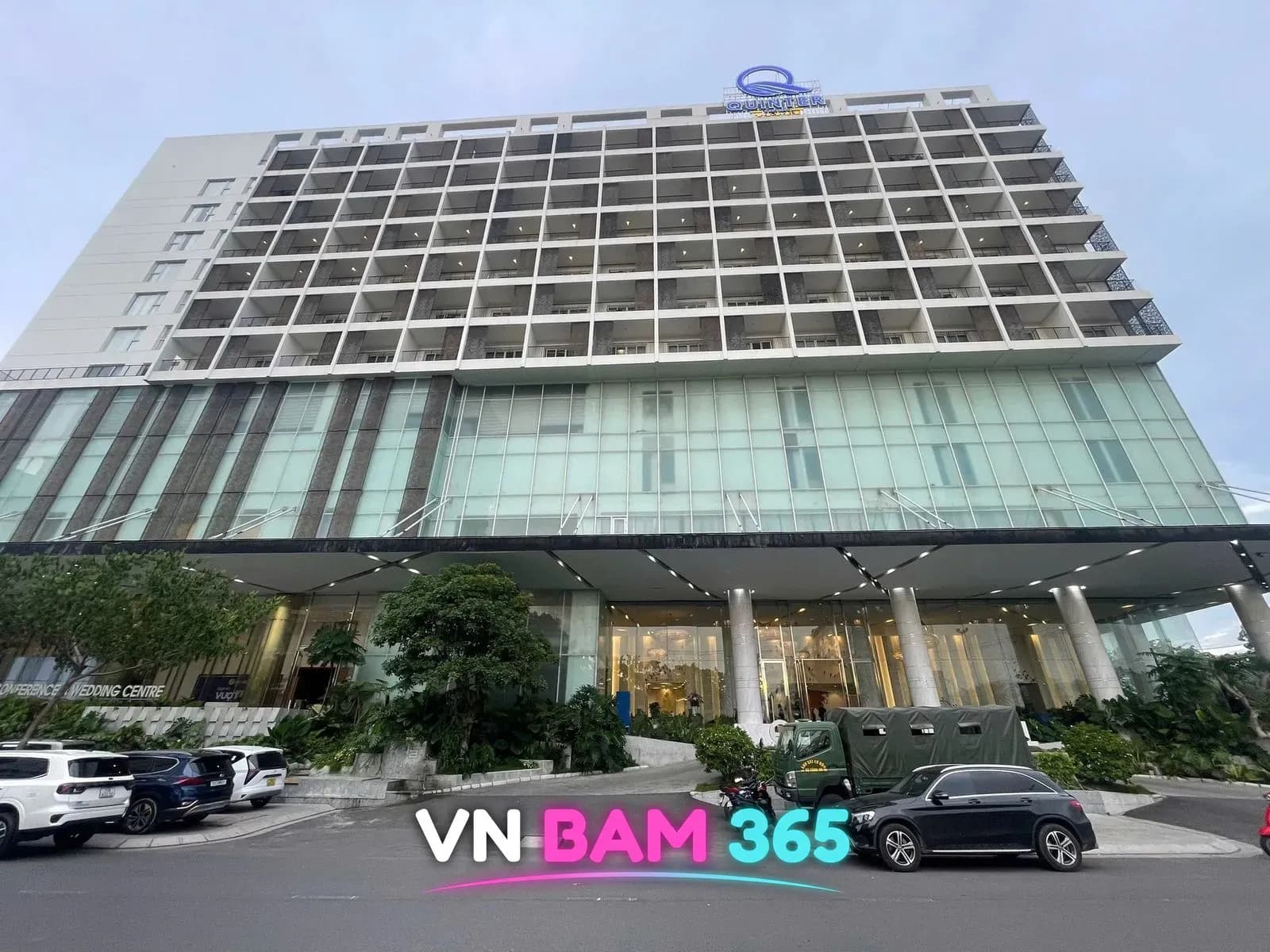 나트랑 퀸터 센트럴 호텔 주간 외관과 앞 도로의 주차 차량