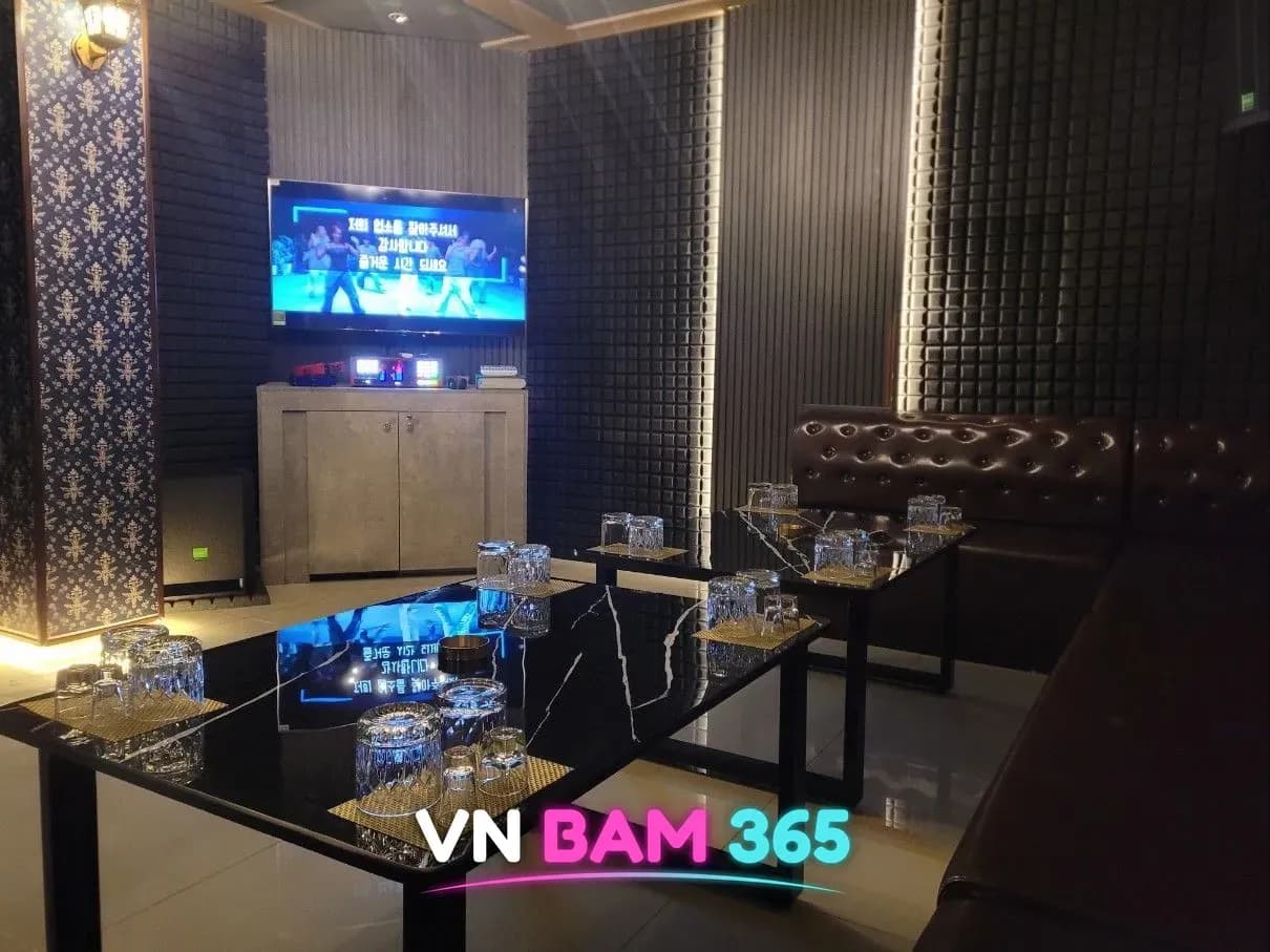 나트랑 X바 노래방 룸, 한국어 자막 화면과 가죽 소파, 대리석 테이블
